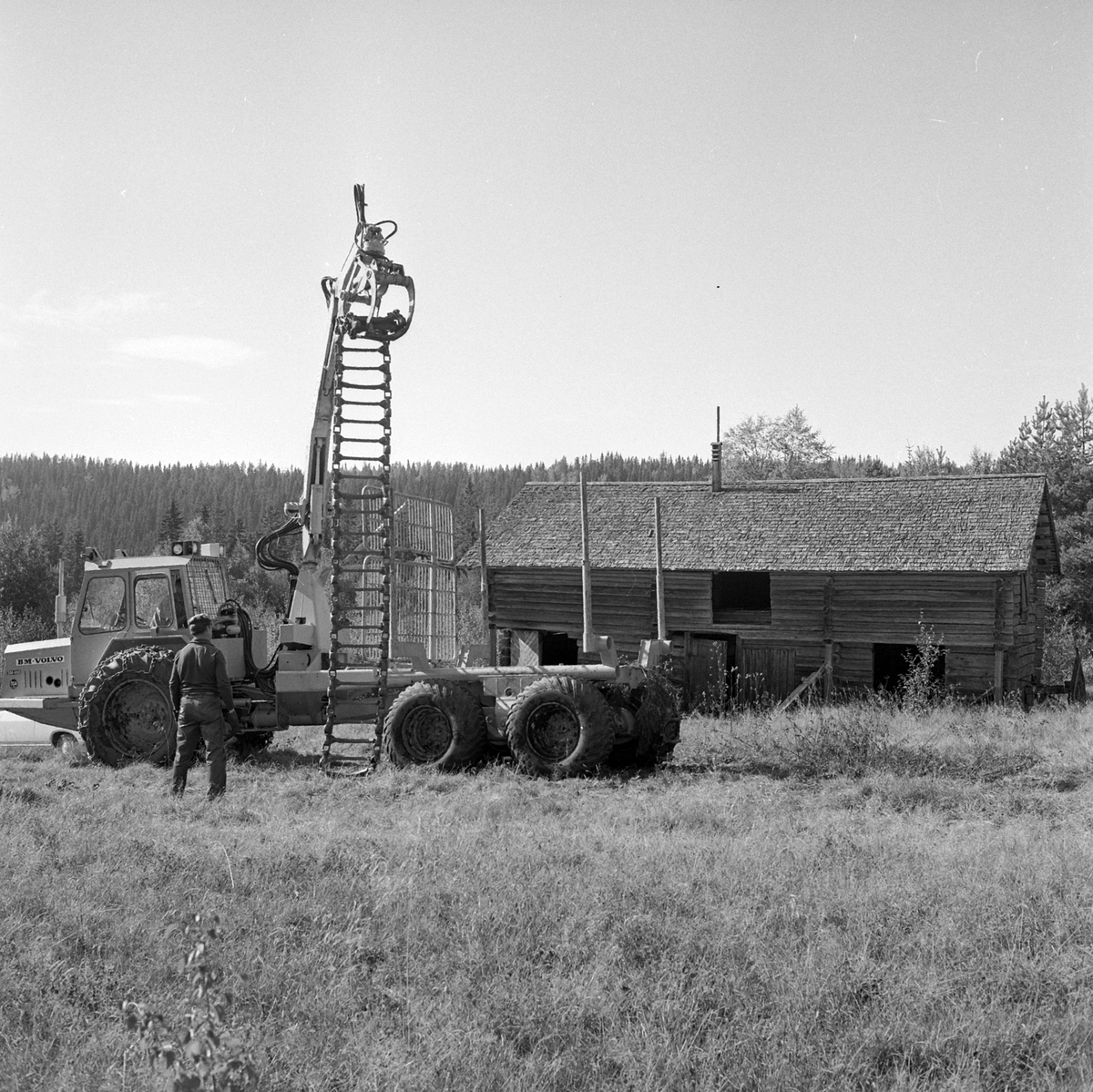 Adolf Skjegstad, En lastbærer for tømmertransport i skog. To personer legger belter på bakhjulene. Tømmerlåve. B.M.Volvo, skogbruk.