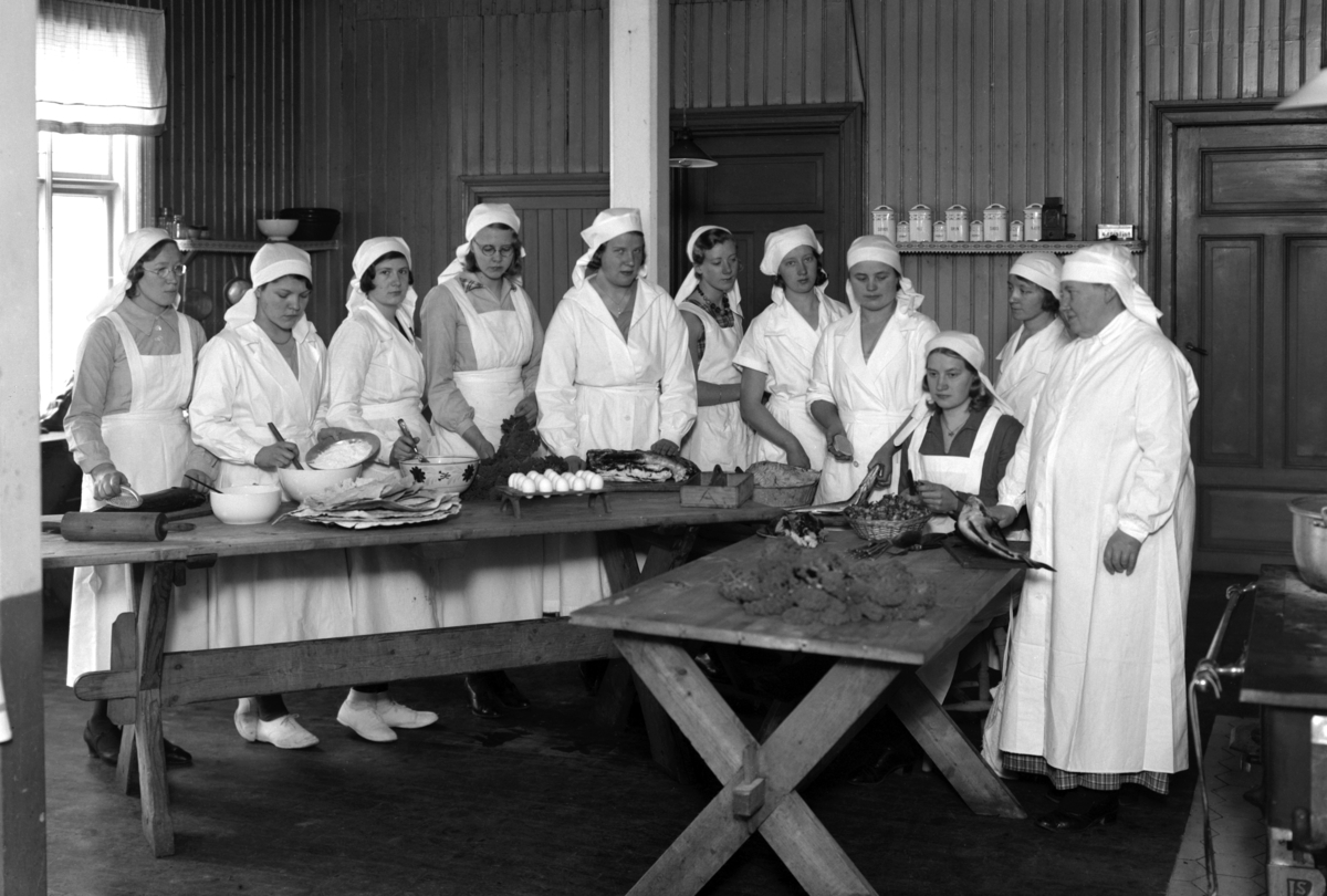 Christian Grundseth, DYSTINGBO HUSTELLSKOLE PÅ RIDABU I HAMAR, HØSTEN 1933, INTERIØR, GR:11, UKJENTE ELEVER, LÆRER, MATLAGING, KJØKKENINTERIØR.