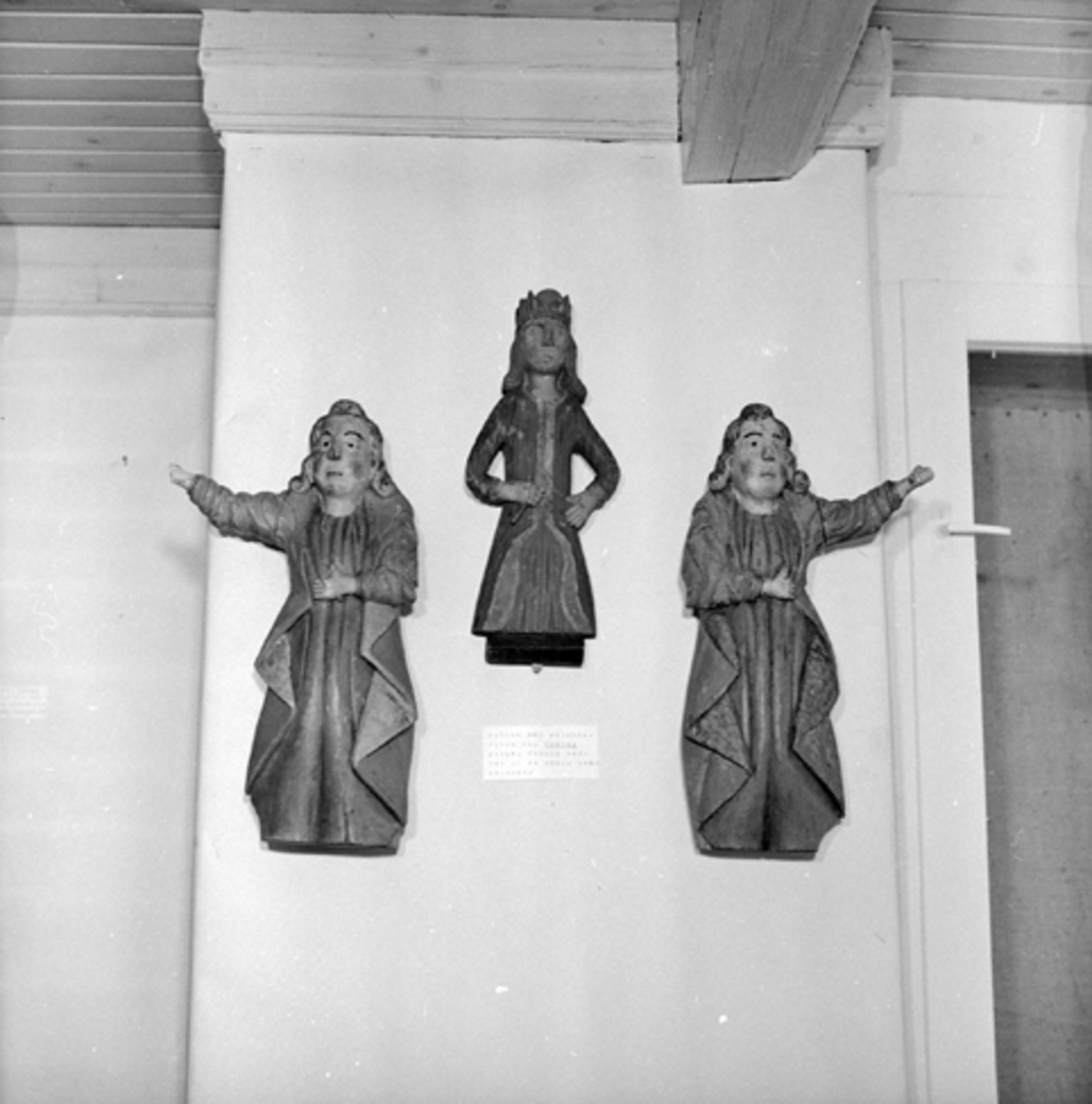 Anno Domkirkeodden, GJENST. KIRKEKUNST, 3 FIGURER FRA TOMTER KIRKE I VALLSET. Antagelig hørt sammen, kanskje fra ei minnetavle. Figurene på sidene har hvitt hår med svart og rød markering. Gulrøde kapper som har henholdsvis brunt og forsølvet for. Blå kjortler. Tilsvarende farger på Kristusfiguren.