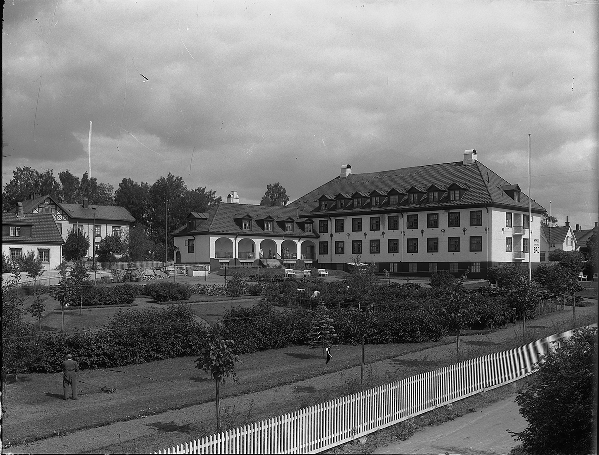 Christian Grundseth, Hamar kommunale bad og gamlehjem i Skolegata. Eksteriør, sommer. Anlegget ble innviet i 1924 og ble bygget etter tegninger fra arkitektfirmaet Morgenstierne & Eide i Kristiania. Murmester Oscar Røhne fra Hamar var hovedentreprenør.