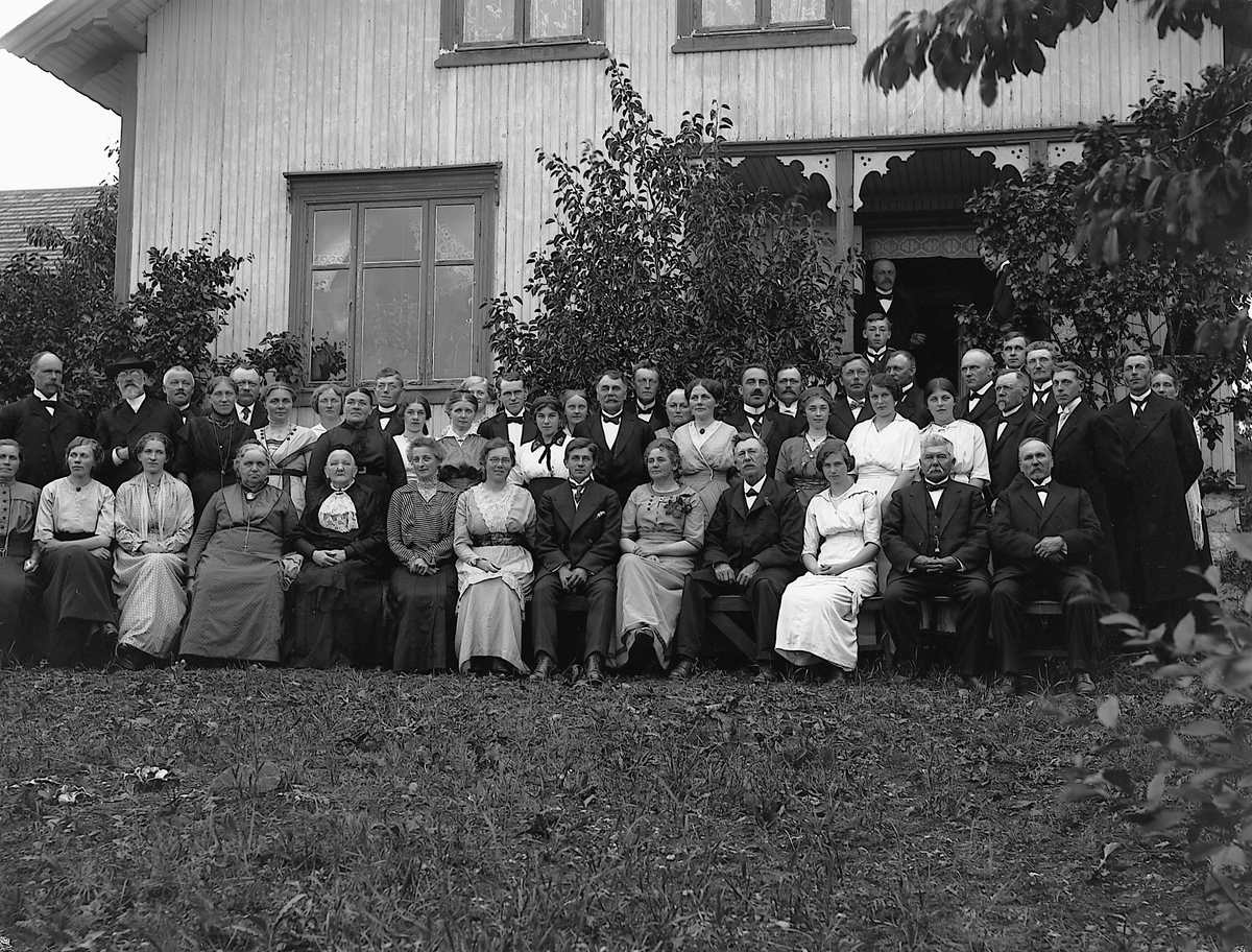 Martin Finborud, Stor gruppe ute på Lille Skjelve ved Hans Hovelsrud (1857-1936) og Marie Pedersdatter Heiberg (1864-1932) sitt sølvbryllup. Bakerst venstre, John Angell Bakken(lærer/kirkesanger)ved siden av Sogneprest Christiansen, bakerst under vindu Karl By, bakerst foran syrin Harald Hoelstad, til høyre Erik Bø…