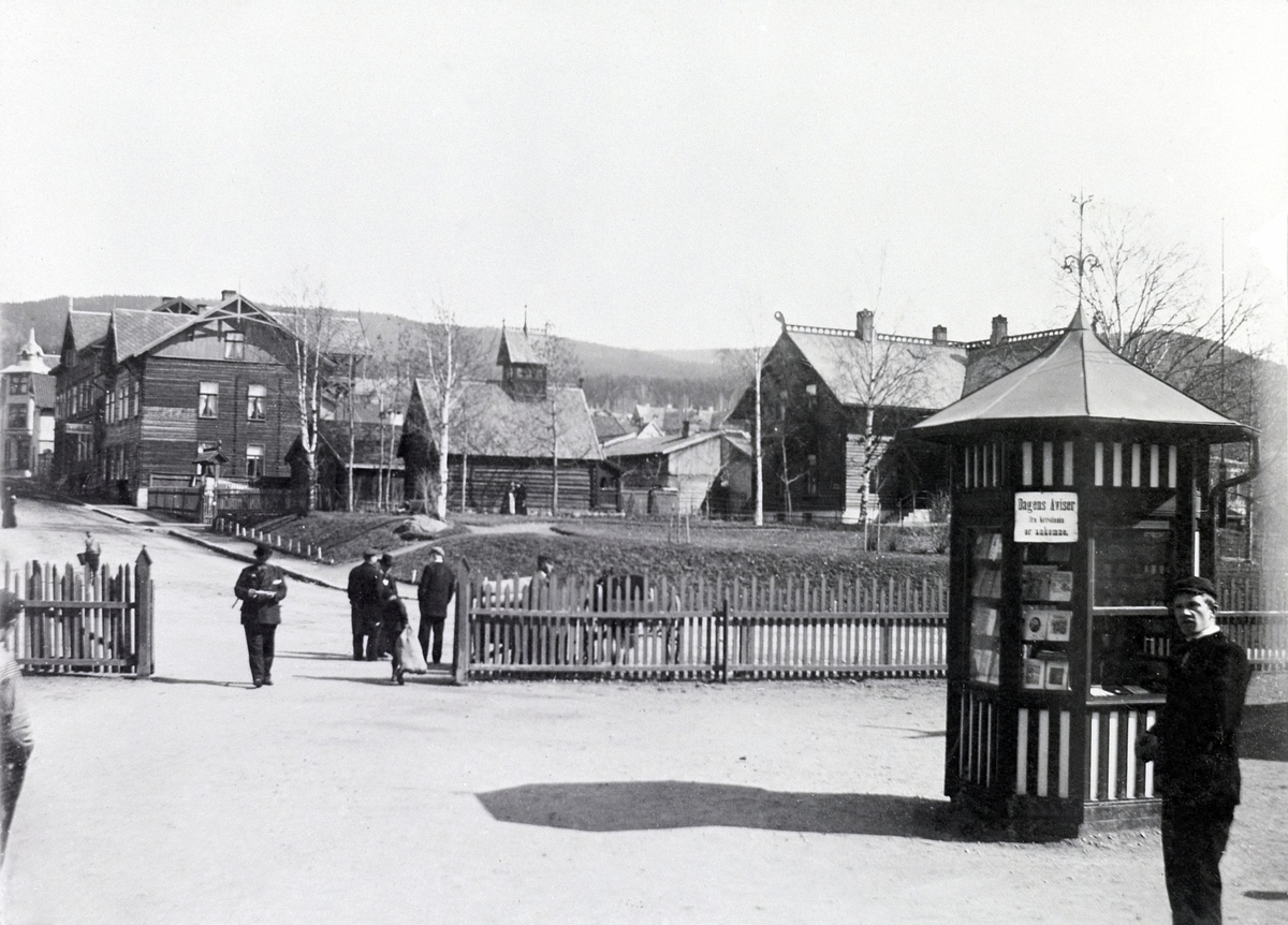 Johan Albert Steen, DE SANDVIGSKE SAMLINGER PÅ LILLEHAMMER VED STASJONEN, ANDERS SANDVIGS SAMLING AV HUS DER HAN HADDE PRAKSIS SOM TANNLEGE, KIOSK. 26-4-1901. Kiosk, plakat. "Dagens aviser fra Kristiania er ankommet"
