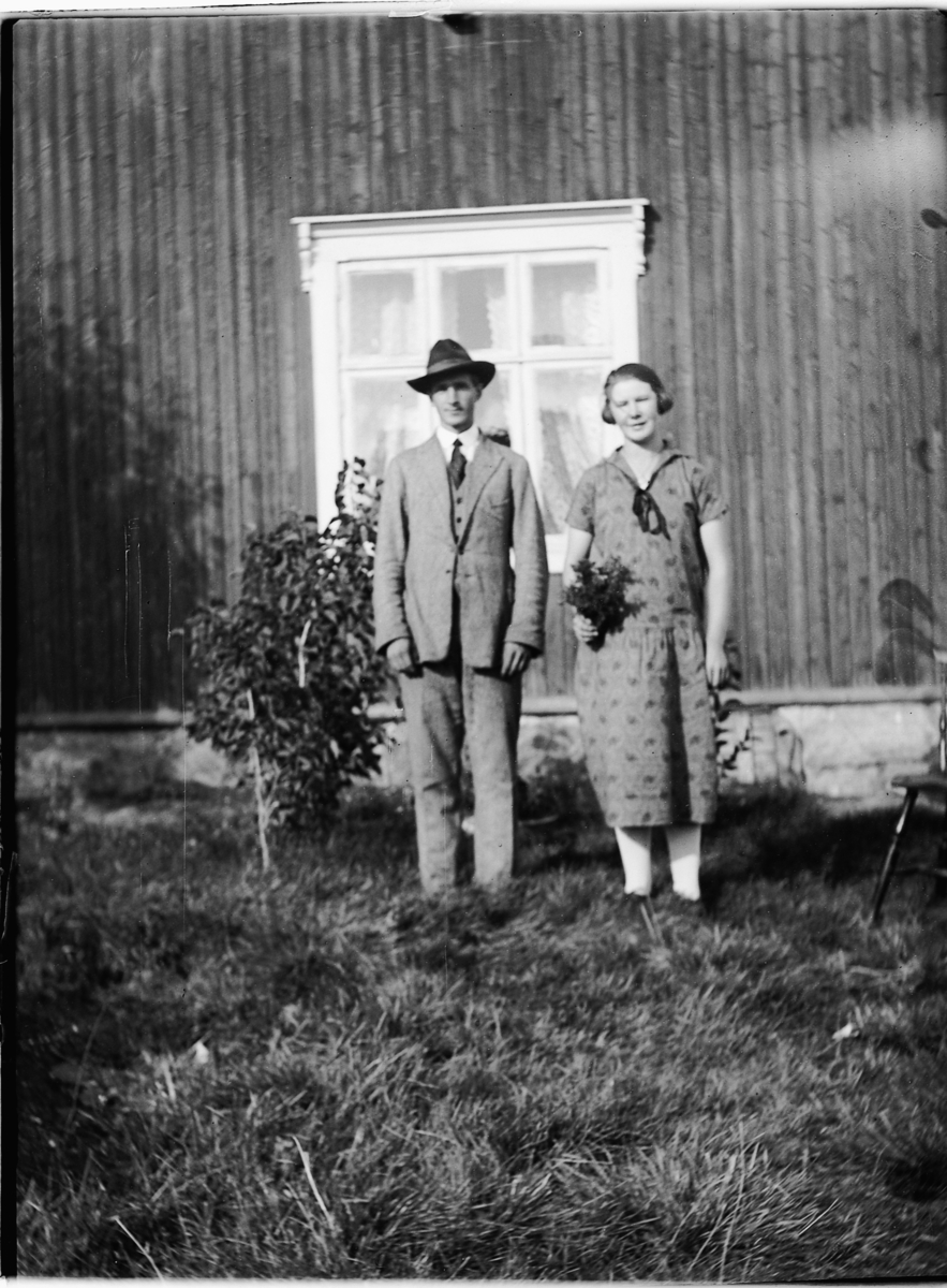 Ole M Martinsen, Ukjent mann og kvinne foran et ukjent hus. Hun holder blomster.