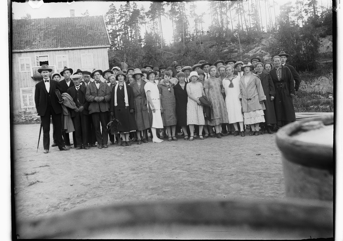 Ole M Martinsen, Stor gruppe ukjente personer. Lengst til venstre står ordfører i Løten; Oscar Wilhelm Nilssen. Oscar W. Nilssens kone, Jørgine Nilssen står som nr. 2 fra høgre med mørk frakk.