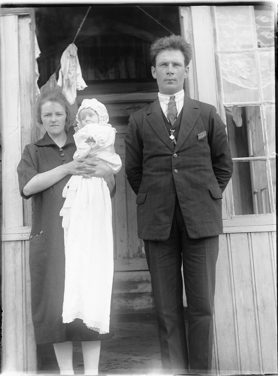 Ole M Martinsen, Ukjent kvinne og mann med et barn ved inngangspartiet til et hus.