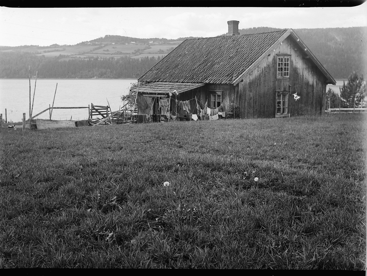 Mikkel Sveinhaug, HEGGENHAUGSTØEN, NES, HUSMANNSPLASS, FERGESTED OG GJESTGIVERI CA. 1920. Klesvasken henger ute til tørk. Utsikt over Mjøsa.