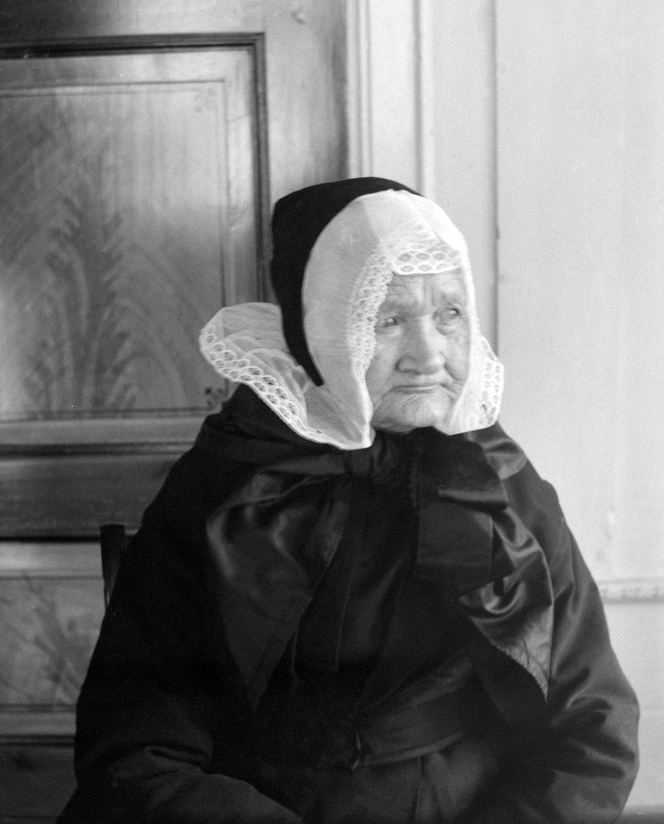 Ole Hansen Løken, MARTHE LØKEN, F. 1831, FØDERÅDSKONE PÅ LØKEN ØSTRE på Rudshøgda i Ringsaker, SKRUVELUE, KVINNEDRAKT. Marthe Løken født på Biri i 1831. Her er hun fotografert på sine eldre dager på Løken Østre i Veldre. Der levde hun som enke og føderådskone til hun døde i 1909. Hodeplagg, skruvelue.