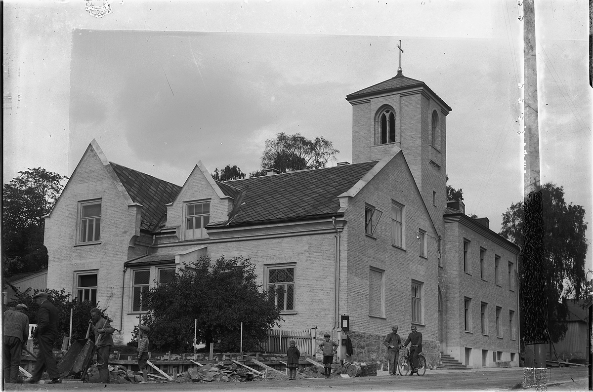 Oscar Løberg, ST. TORFINNS KATOLSKE SYKEHUS OG KIRKE, ETTER OMBYGGING, HAMAR. Arbeidsfolk, barn og passerende. Grunnsteinen for St. Torfinns øyeklinikk ble lagt ned i 1930 og nybygget kunne tas i bruk i 1932.