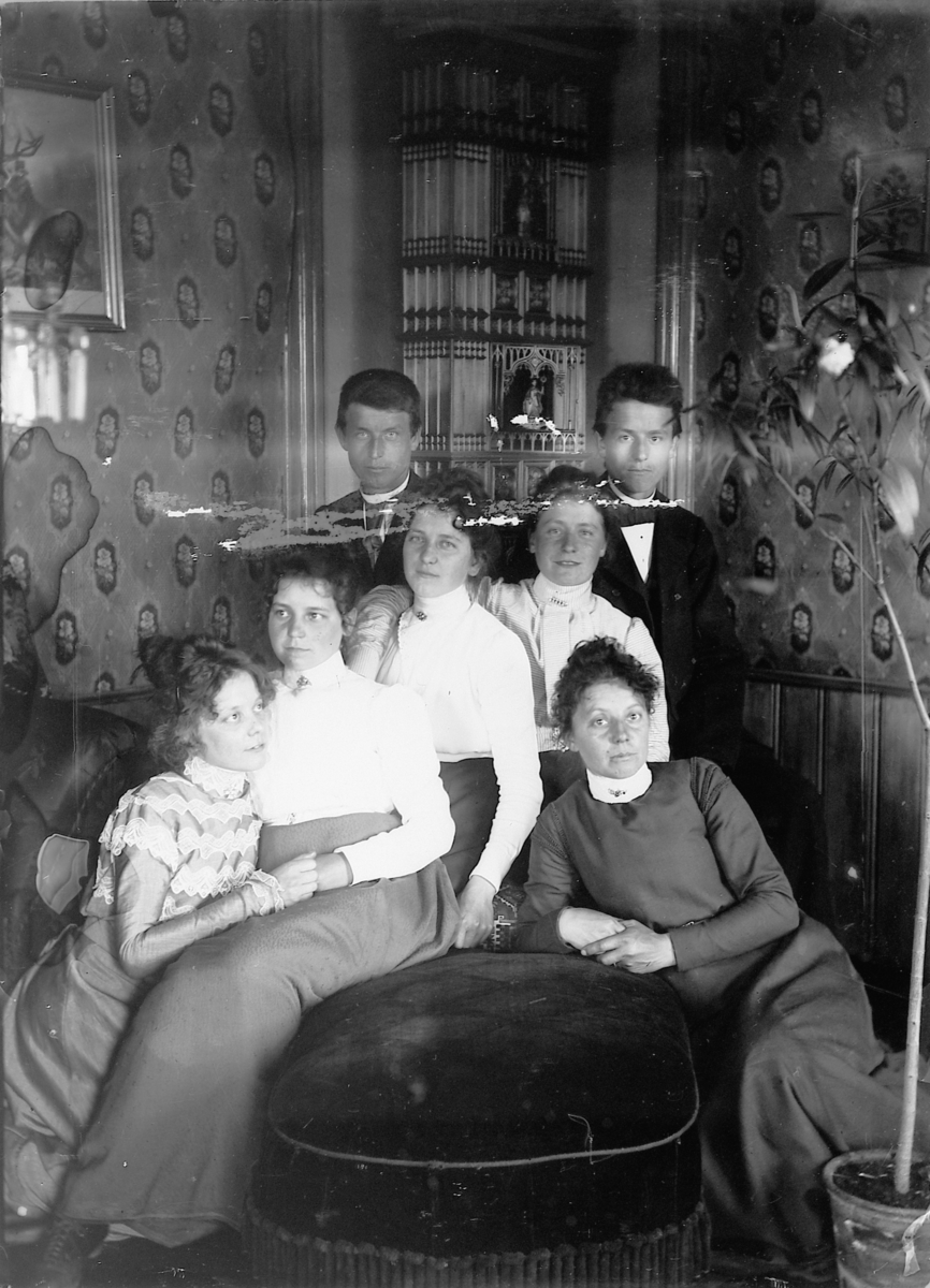 Mina Skraastad, Interiør, stue. En gruppe, familie på en sofa.