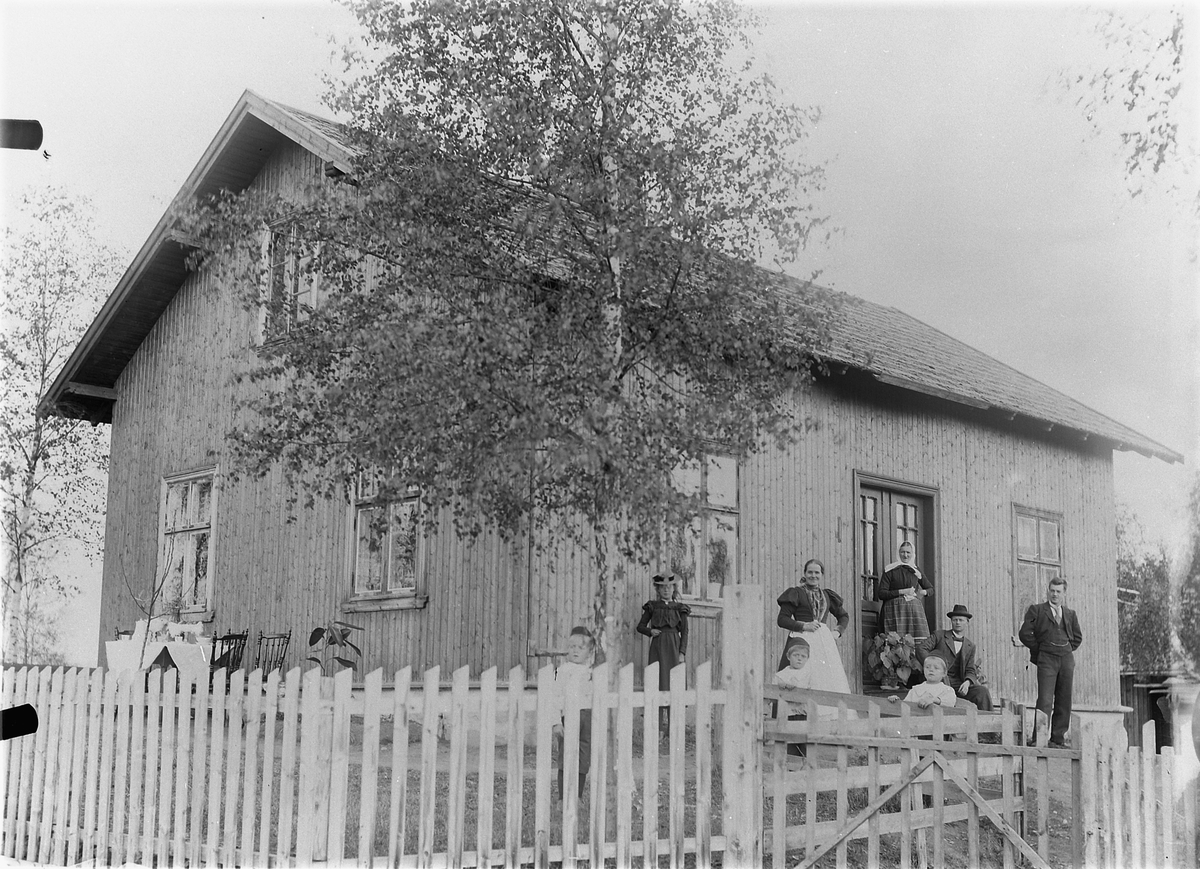 Mina Skraastad, Ukjent familie med to barn foran et hus.
