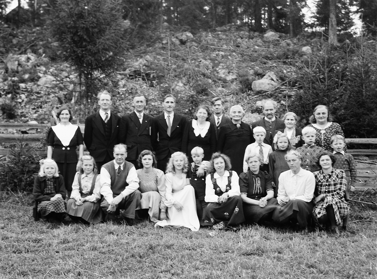 Håkon Prestkværn, Familiegruppe, konfirmasjon. Foto tatt 5. oktober 1947 ved konfirmasjonen til Anne Karoline Langgård på Nedre Langgård i Næroset. Personene på bildet: Bak fra venstre: Laura Sagstuen (født Langgård), Hans Langgård, Gunnar Elvsvebakken, Sigvald Langgård, Sigrid Borgersen, Olaf Bjerkevold, Birgitte B…