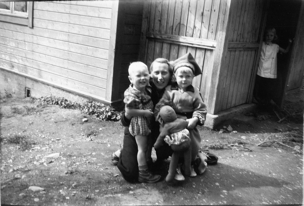 Håkon Prestkværn, Kvinne med tre barn, Gunhild Prestkværn (f. Reksten) med Brita Prestkværn (m/lue) og et ukjent barn.