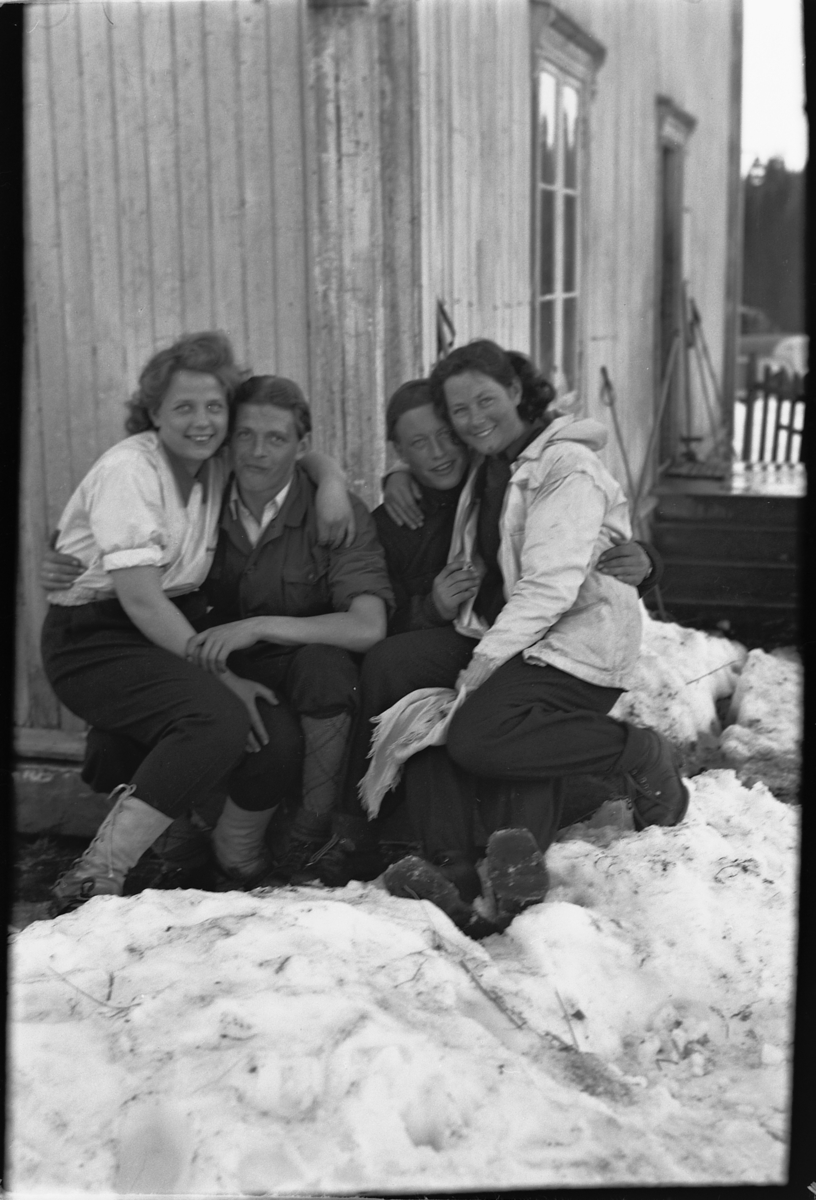 Håkon Prestkværn, To ukjente par, kvinner og menn, foran et hus.