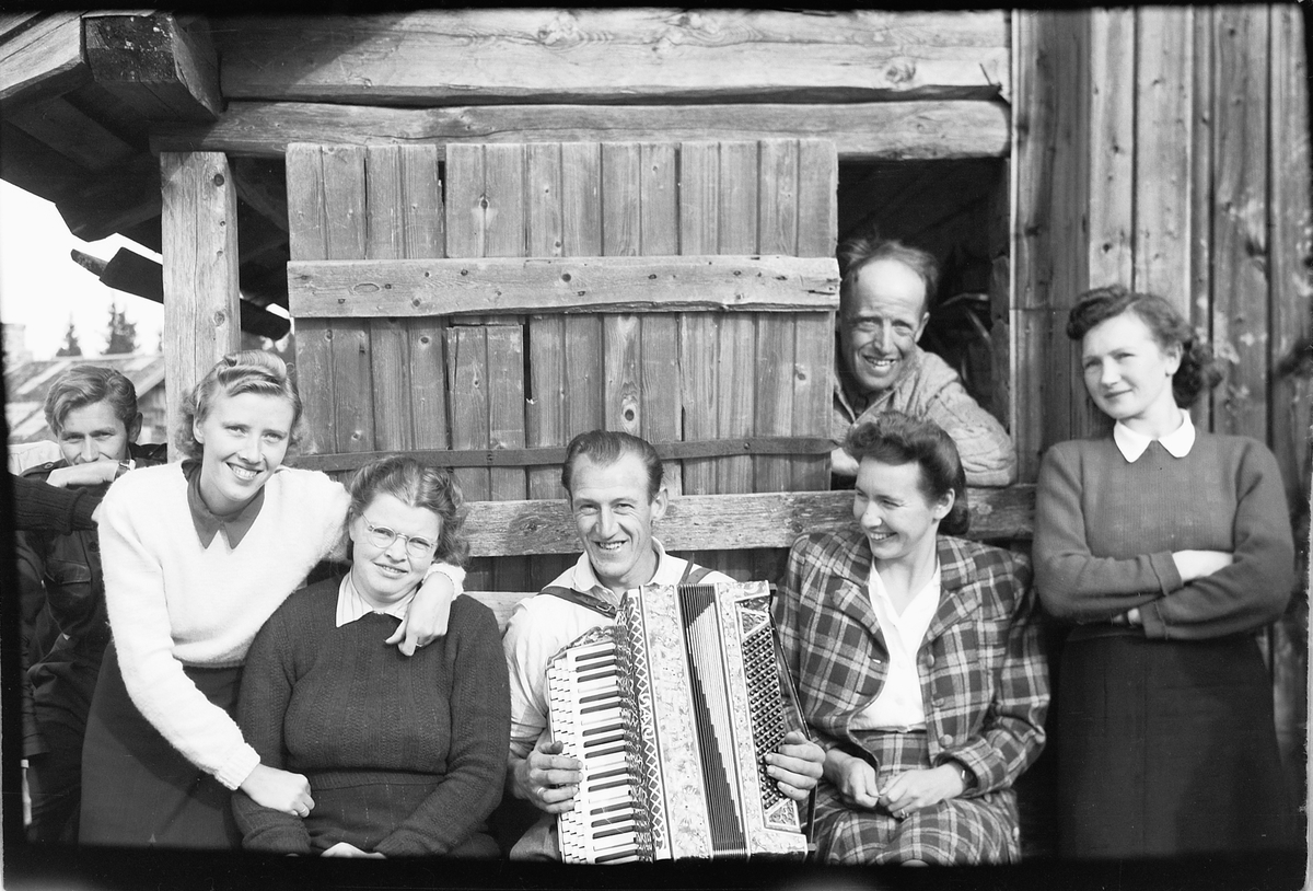 Håkon Prestkværn, Kvinner og menn rundt en mann som spiller trekkspill.