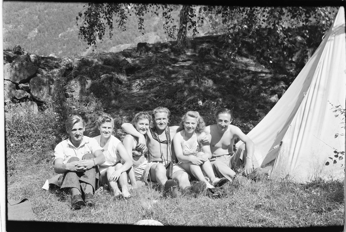 Håkon Prestkværn, Gruppe 6 personer. Campingturister sitter foran et telt, Håkon Prestkværn nummer fire fra venstre, resten av peronene er ukjente.