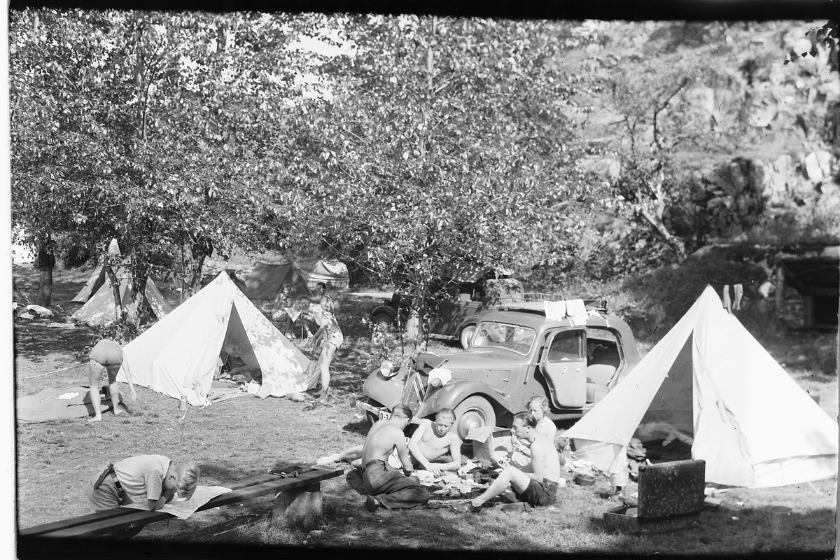 Håkon Prestkværn, Campingplass, telt, ferietur, Nærmeste bil er en Citroën Traction Avant. Siden produksjonen ikke kom i gang før litt ut i 1934, er det trolig tidligst 1935-modell. Men i hvert fall førkrigs, siden den har luker i panseret. Ventilasjon med riller kom først i 1946.