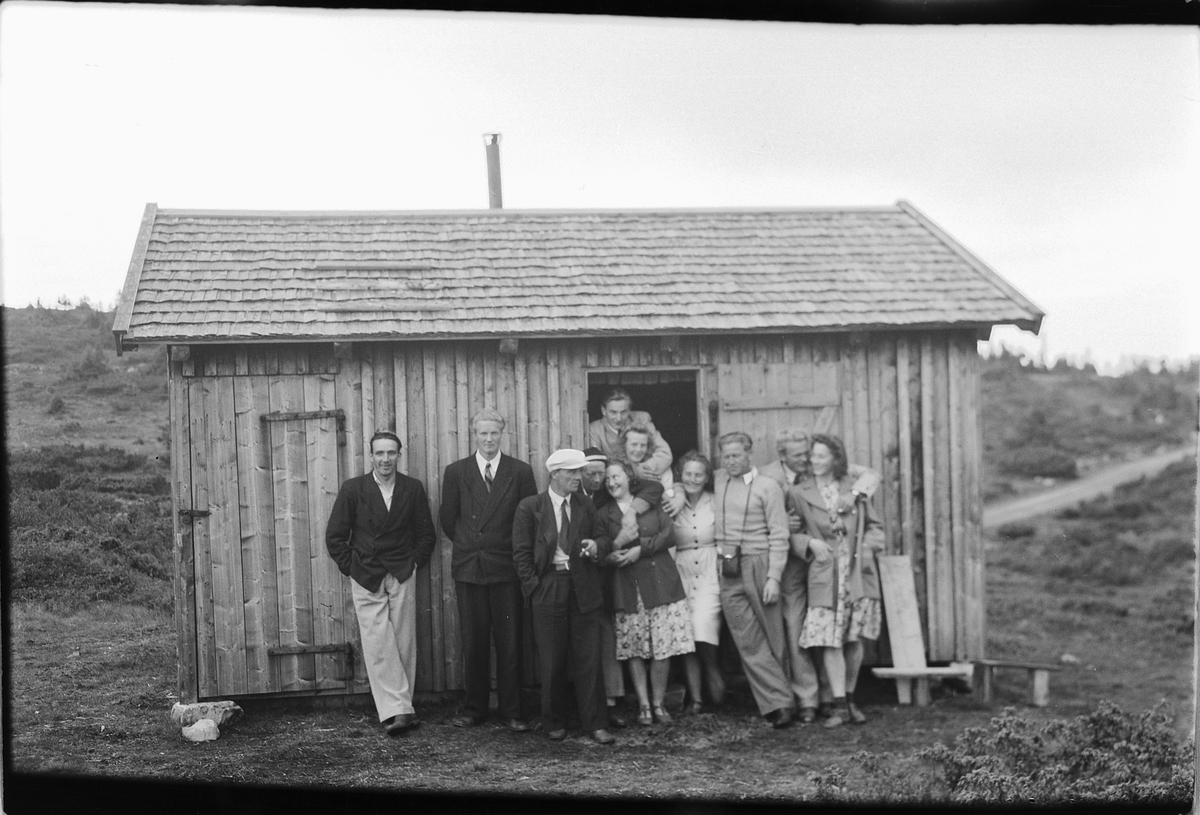 Håkon Prestkværn, Ukjente menn og kvinner foran et uthus.