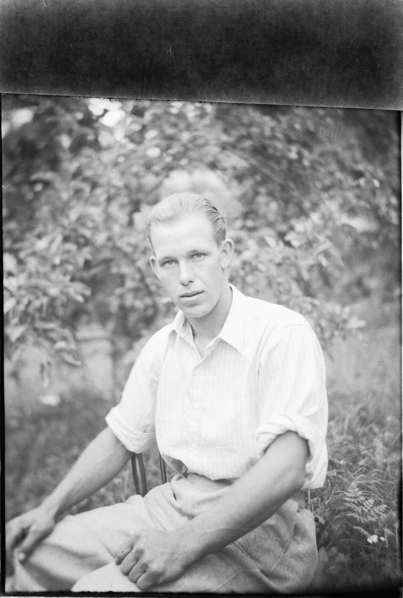 Håkon Prestkværn, Ukjent mann sitter på en stol i en hage.