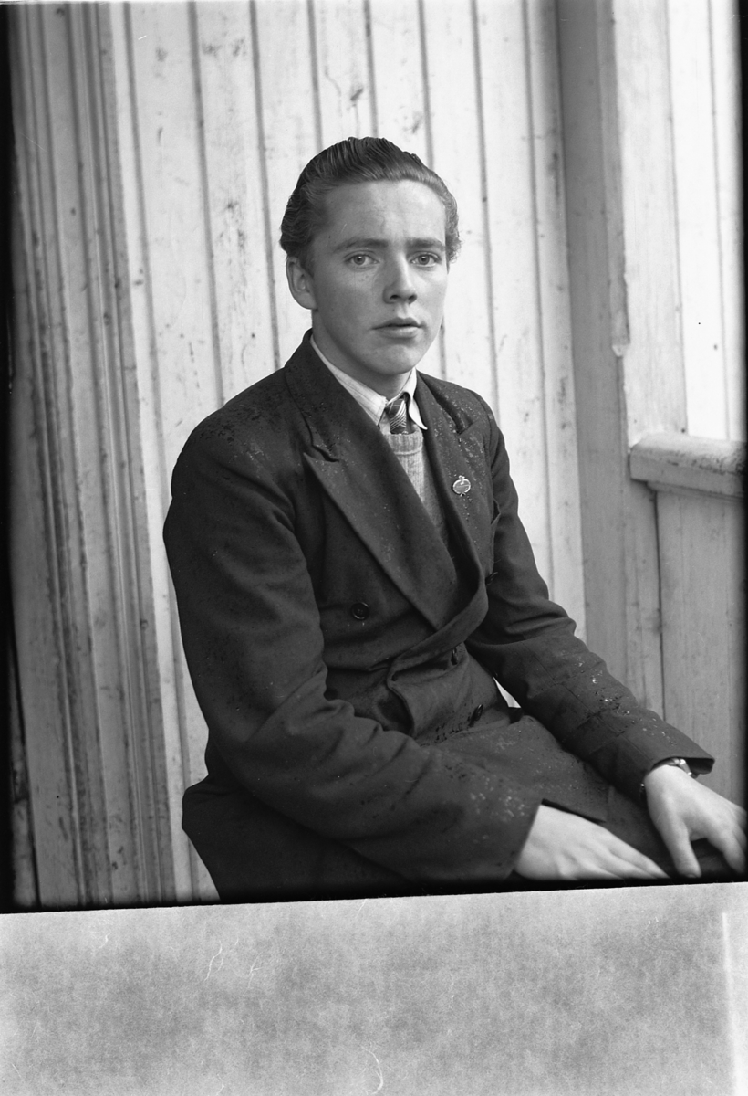 Håkon Prestkværn, Ukjent mann med dress og slips på trammen.