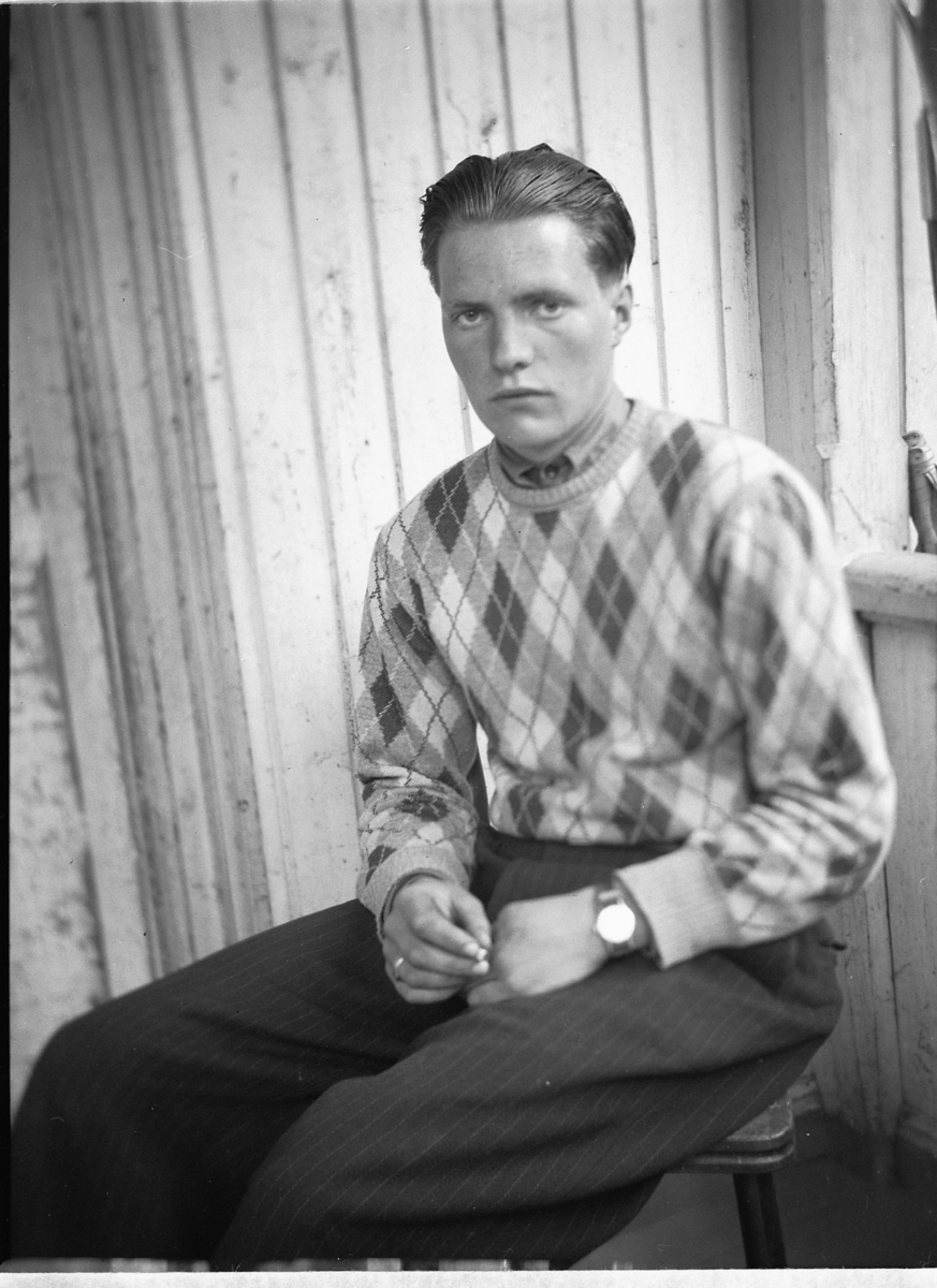 Håkon Prestkværn, Ukjent mann sitter i en stol på trammen.