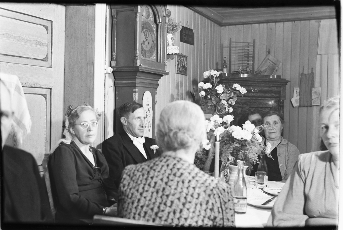 Håkon Prestkværn, Interiør med bestefar klokke. Ukjent familie samlet rundt middagsbordet ved en festlig anledning.