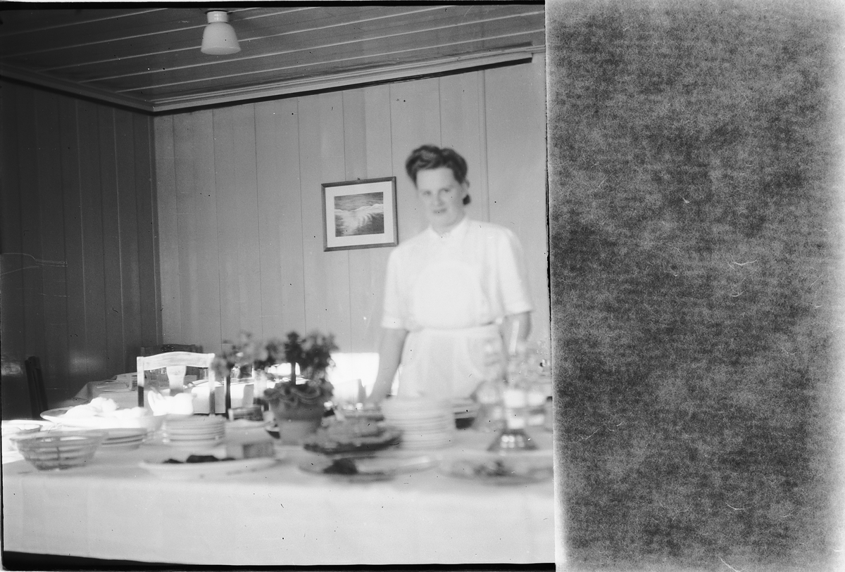 Håkon Prestkværn, Ukjent kvinne foran et bord med servise og kaker.