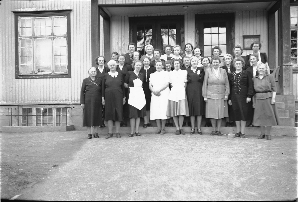 Håkon Prestkværn, Stor gruppe kvinner ved trapp til et hus.