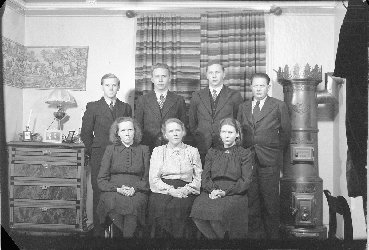 Håkon Prestkværn, Interiør, stue med ovn. Ukjent familiegruppe.