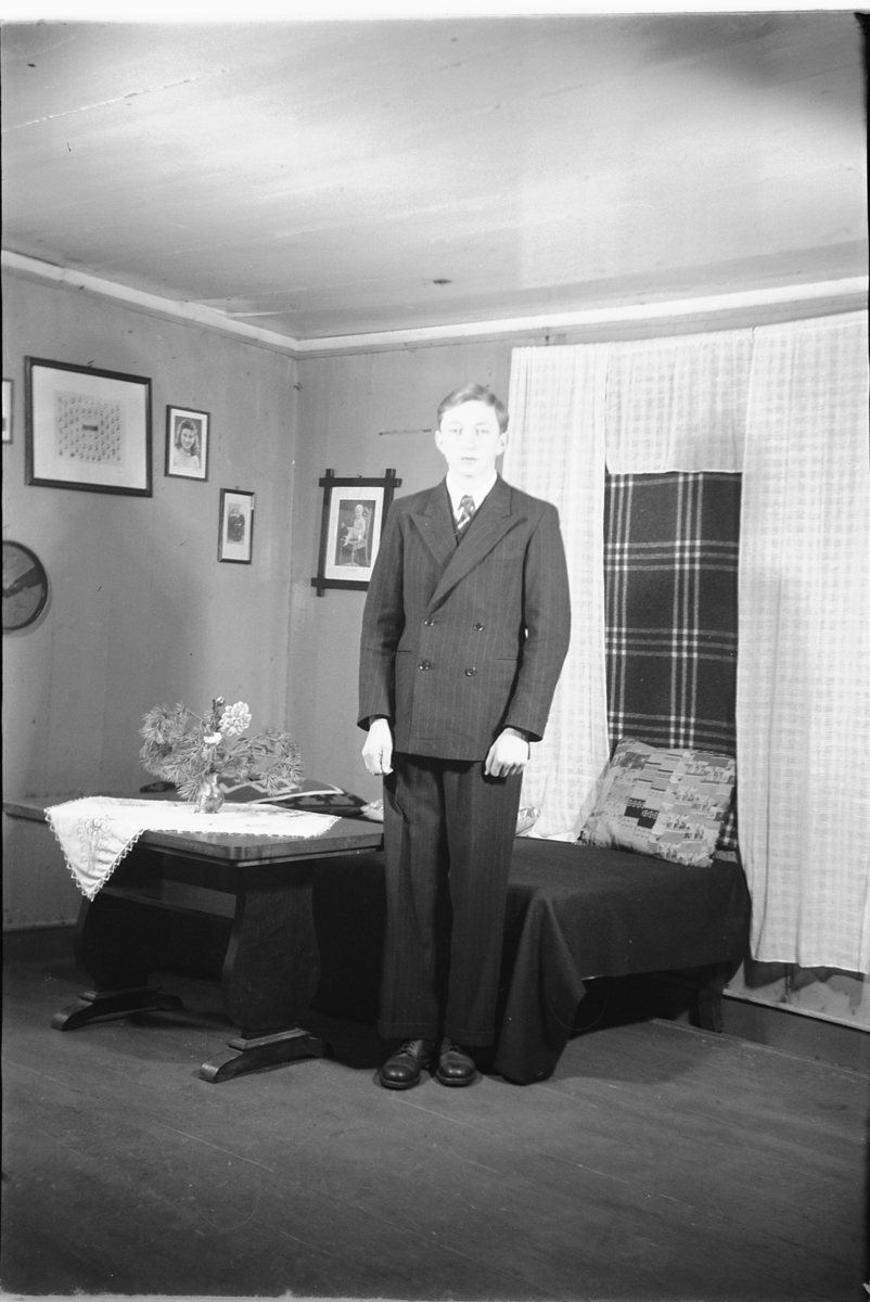 Håkon Prestkværn, Interiør, stue. Ukjent gutt med dress og slips.