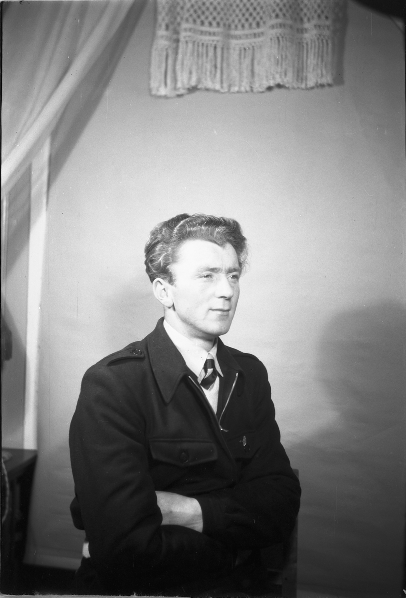 Håkon Prestkværn, Ukjent mann med dress og slips.
