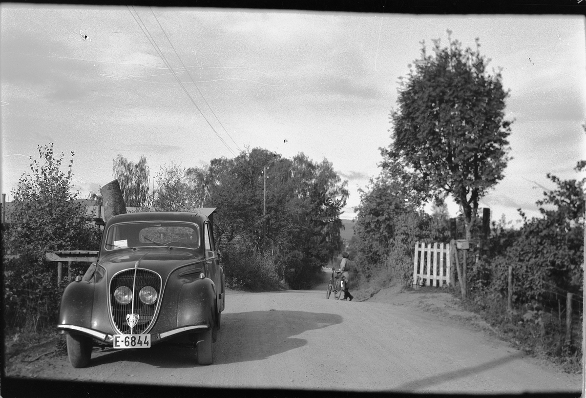 Håkon Prestkværn, Landevei med en bil og ei kvinne med sykkel. Bilen er en Peugeot 201 fra sent 40 tall. Reg. nr. E-6844