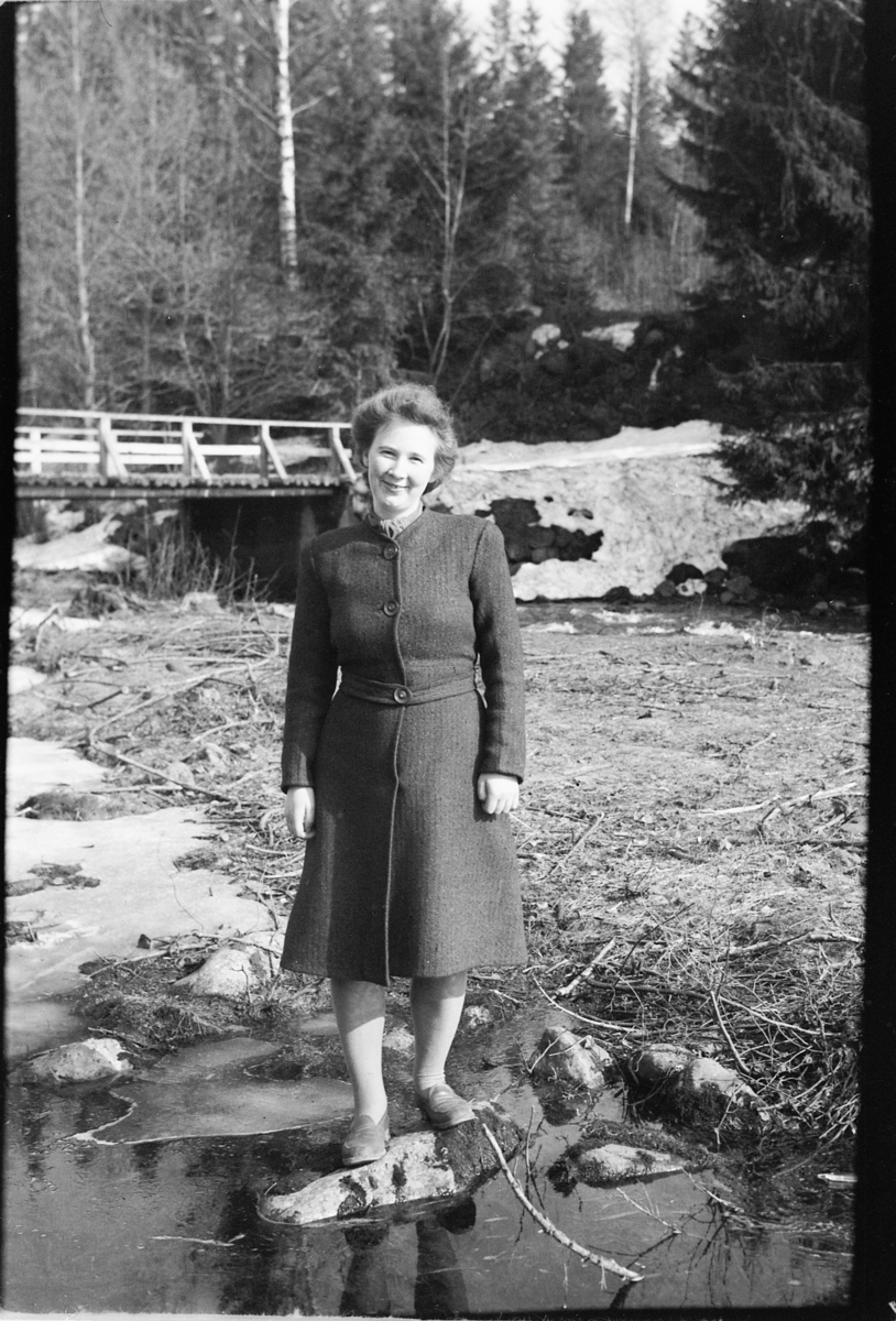 Håkon Prestkværn, Ukjent kvinne står ved ei elv. Fotokonvolutt mrk. "Frknr. Hagen slutten april 1948"