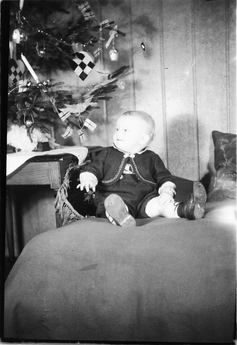 Håkon Prestkværn, Interiør, stue med juletre. Baby sitter i en sofa. "fotokonvolutt mrk. Aaseth julen 1948"