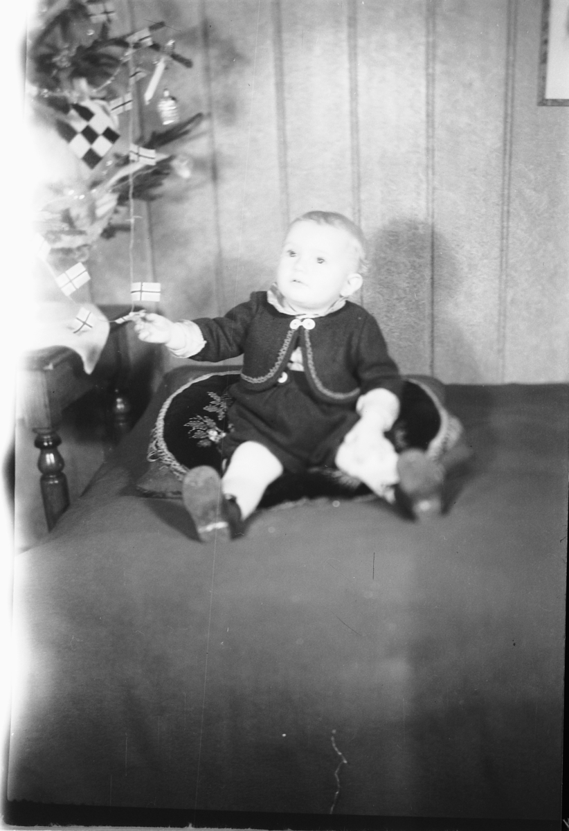 Håkon Prestkværn, Interiør, stue med juletre. Baby sitter i en sofa. "fotokonvolutt mrk. Aaseth julen 1948"