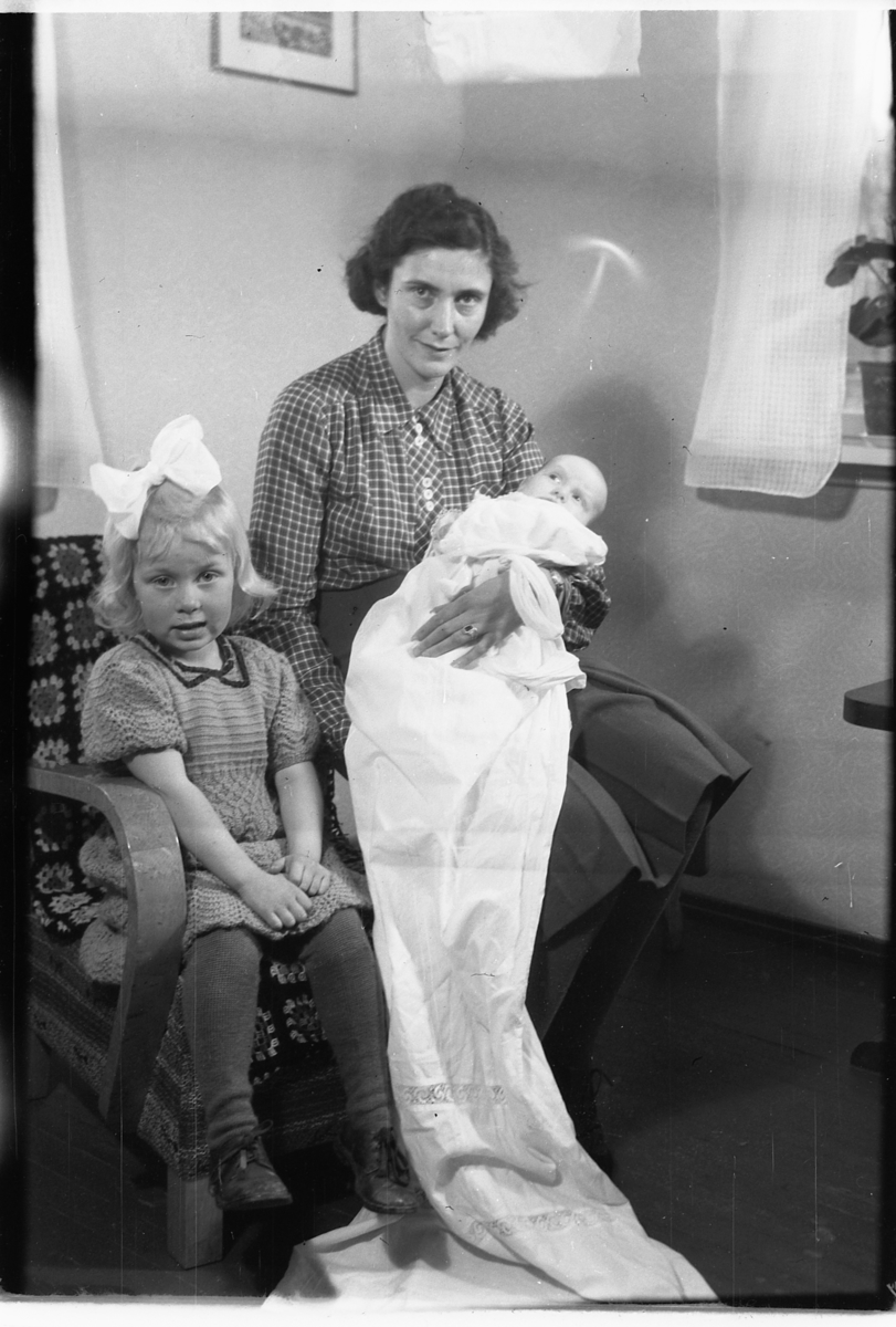 Håkon Prestkværn, Ukjent kvinne med dåpsbarnet Borgny Evensen på fanget, t.v. Edith Evensen med sløyfe i håret.