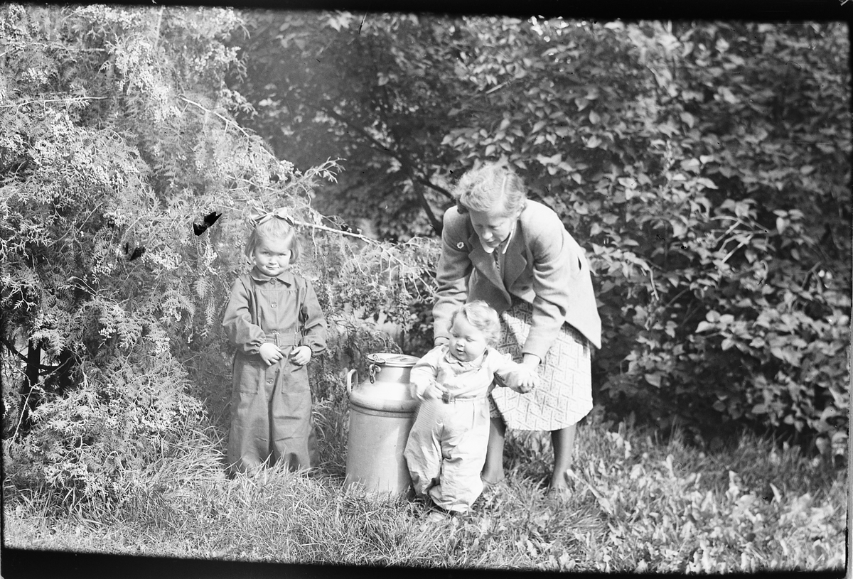 Håkon Prestkværn, Ingrid Bjørge, Moelv, med barna Inger Johanne til venstre og Trond ved et melkespann.