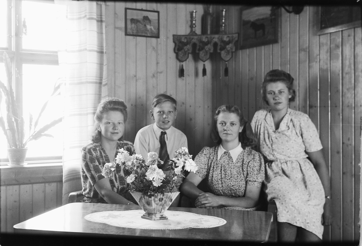 Håkon Prestkværn, Interiør, stue. Tre ukjente kvinner og en gutt i en sofa. Ukjente, Kjos? Ring.