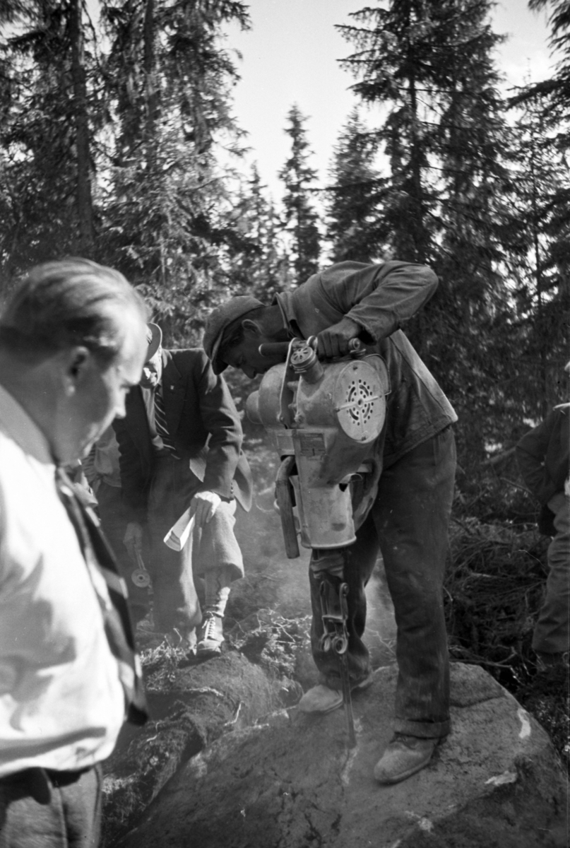 Håkon Prestkværn, Buvika sagbruk, skogbefaring, Ringsaker allmenning. Juni 1949. Ukjent mann borrer i stein.