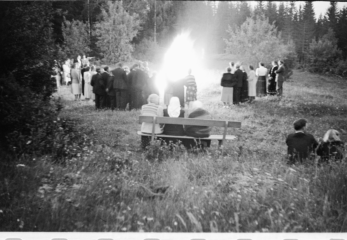 Håkon Prestkværn, Eksteriør. Gruppe mennesker samlet rundt et bål.