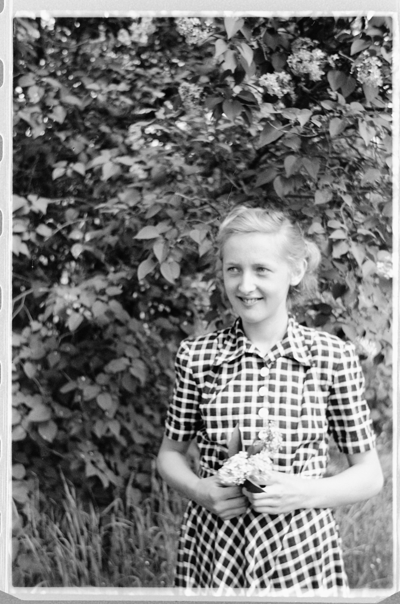 Håkon Prestkværn, Ukjent kvinne i kjole med blomster i hendene.