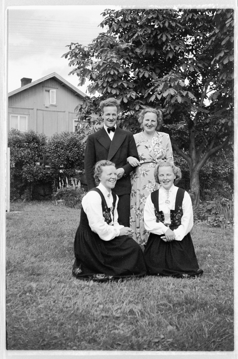 Håkon Prestkværn, Eksteriør, hage. Ukjent mann sammen med tre kvinner, to i bunad. Bryllupsgjester, Brumunddal hotell