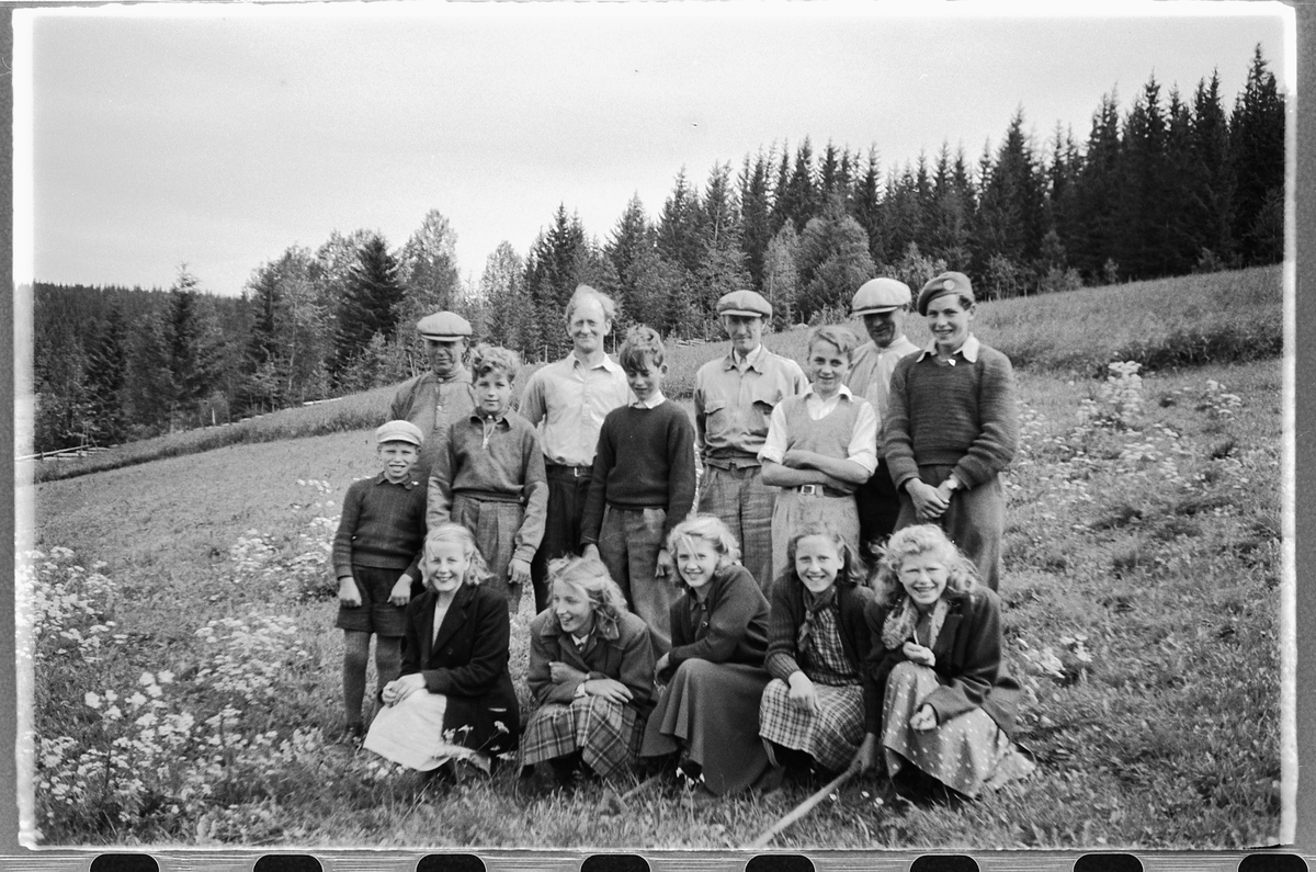 Håkon Prestkværn, Gruppe menn, kvinner og gutter samlet foran et jorde.