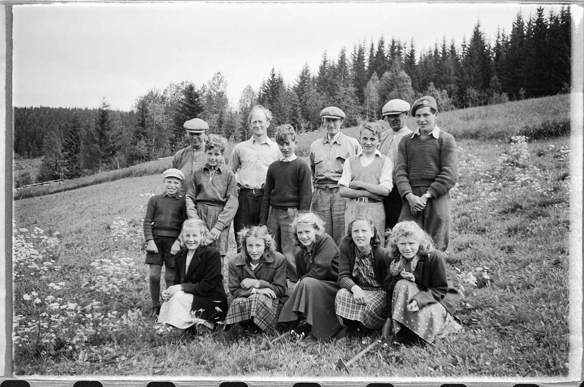 Håkon Prestkværn, Gruppe menn, gutter og jenter samlet foran et jorde.
