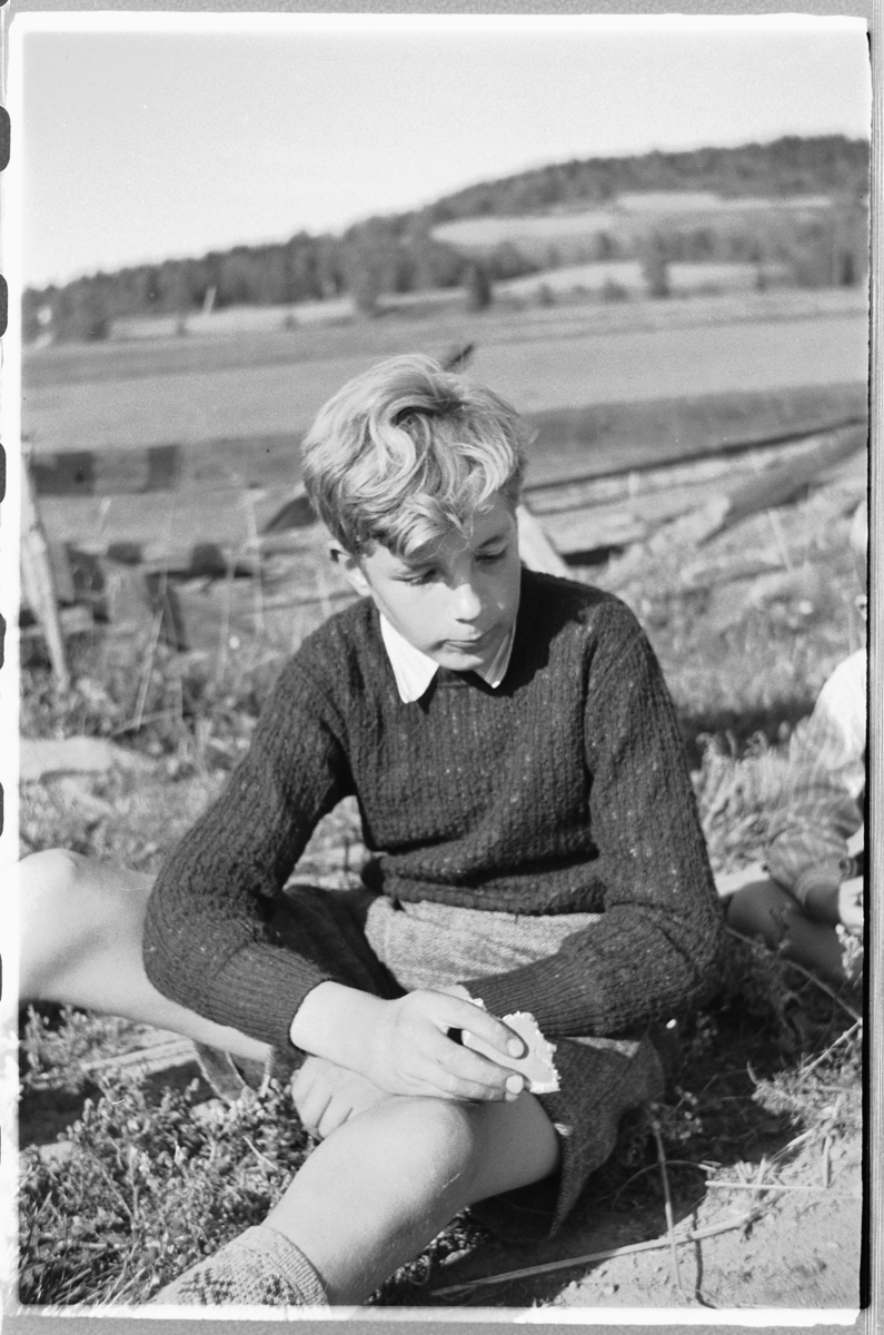 Håkon Prestkværn, Ukjent gutt spiser niste foran et gjerde.