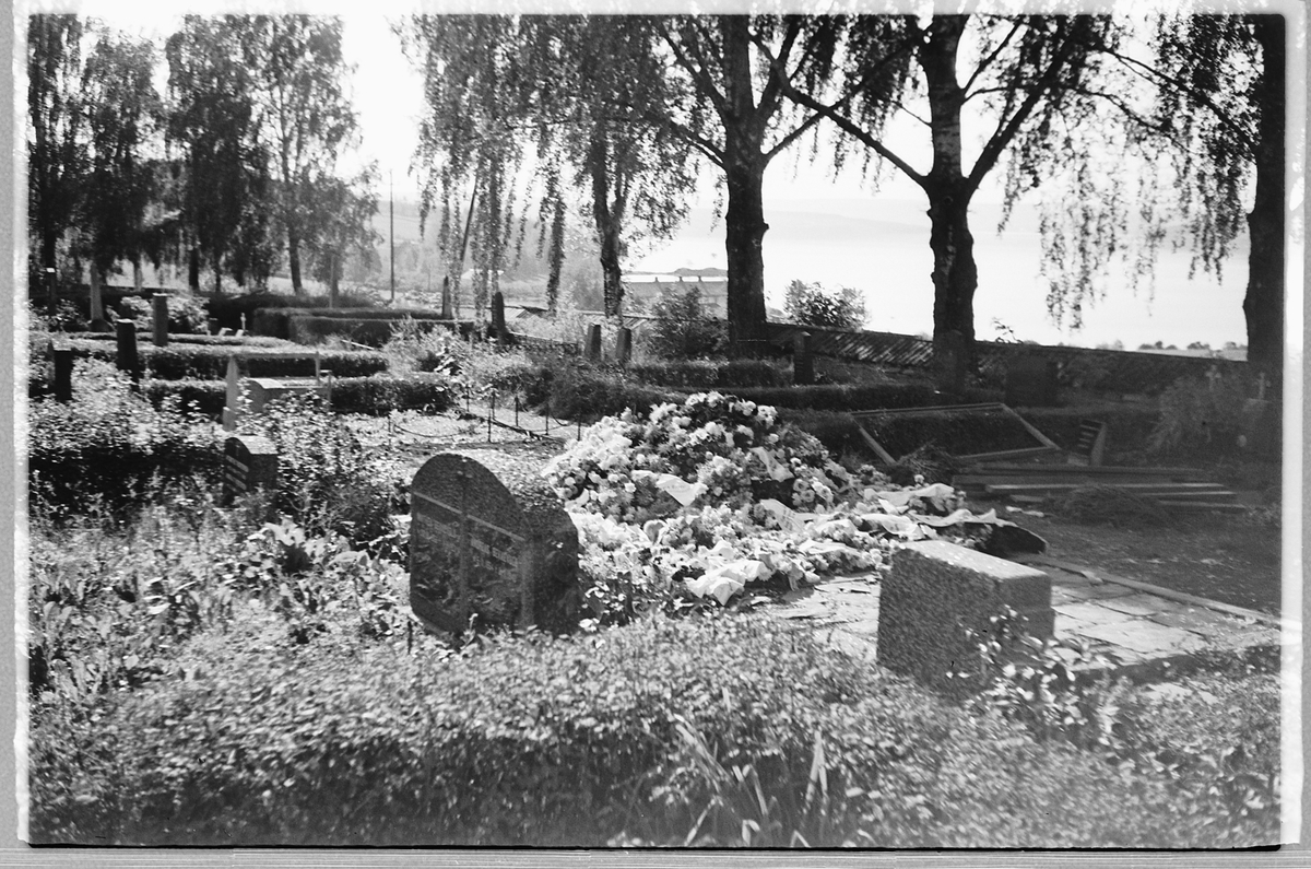 Håkon Prestkværn, En ny grav med blomsterkranser på en kirkegård. Ringsaker.