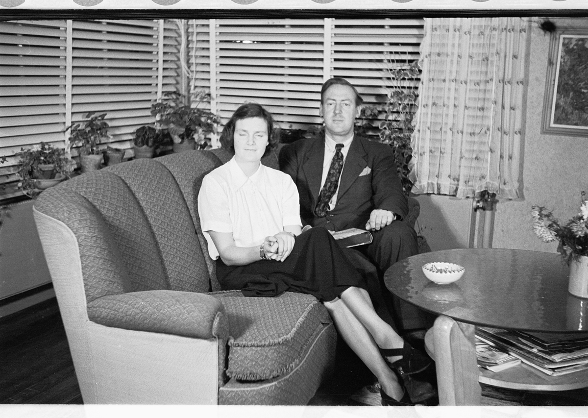 Håkon Prestkværn, Interiør, stue. Kvinne og mann sitter i en sofa.