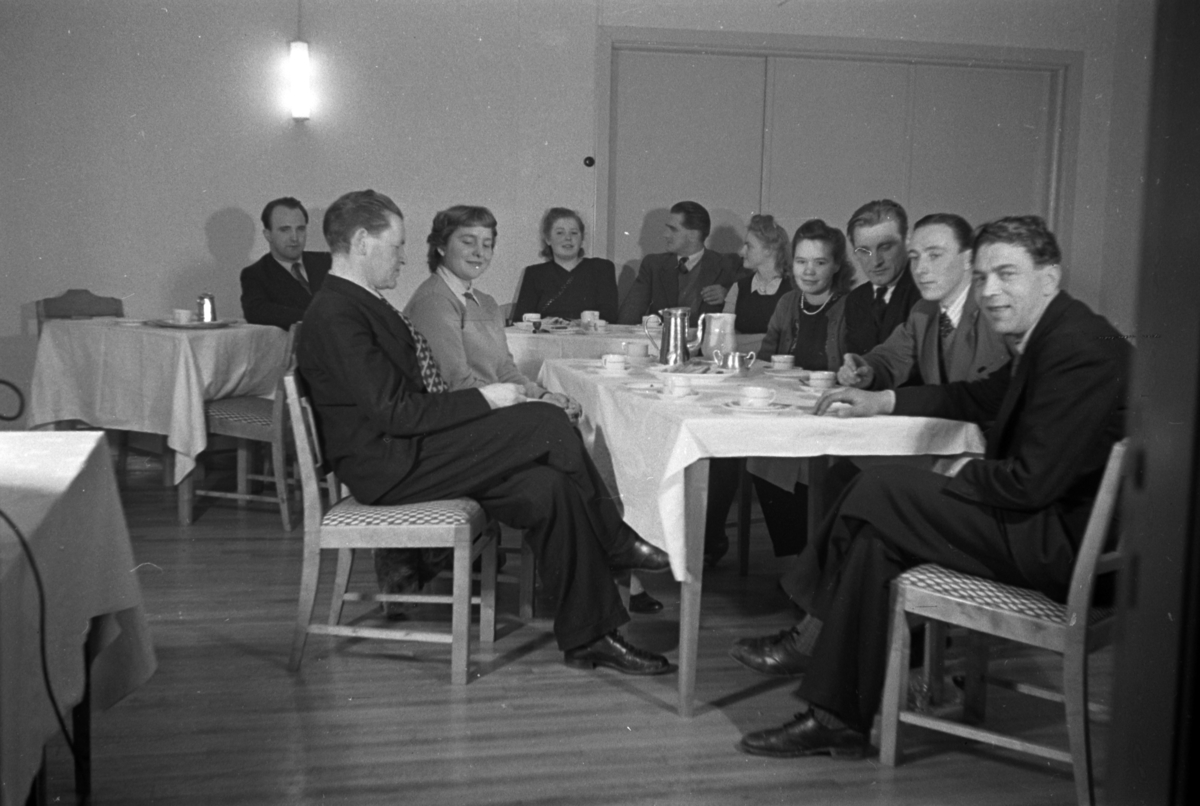 Håkon Prestkværn, Menn og kvinner drikker kaffe rundt et bord.
