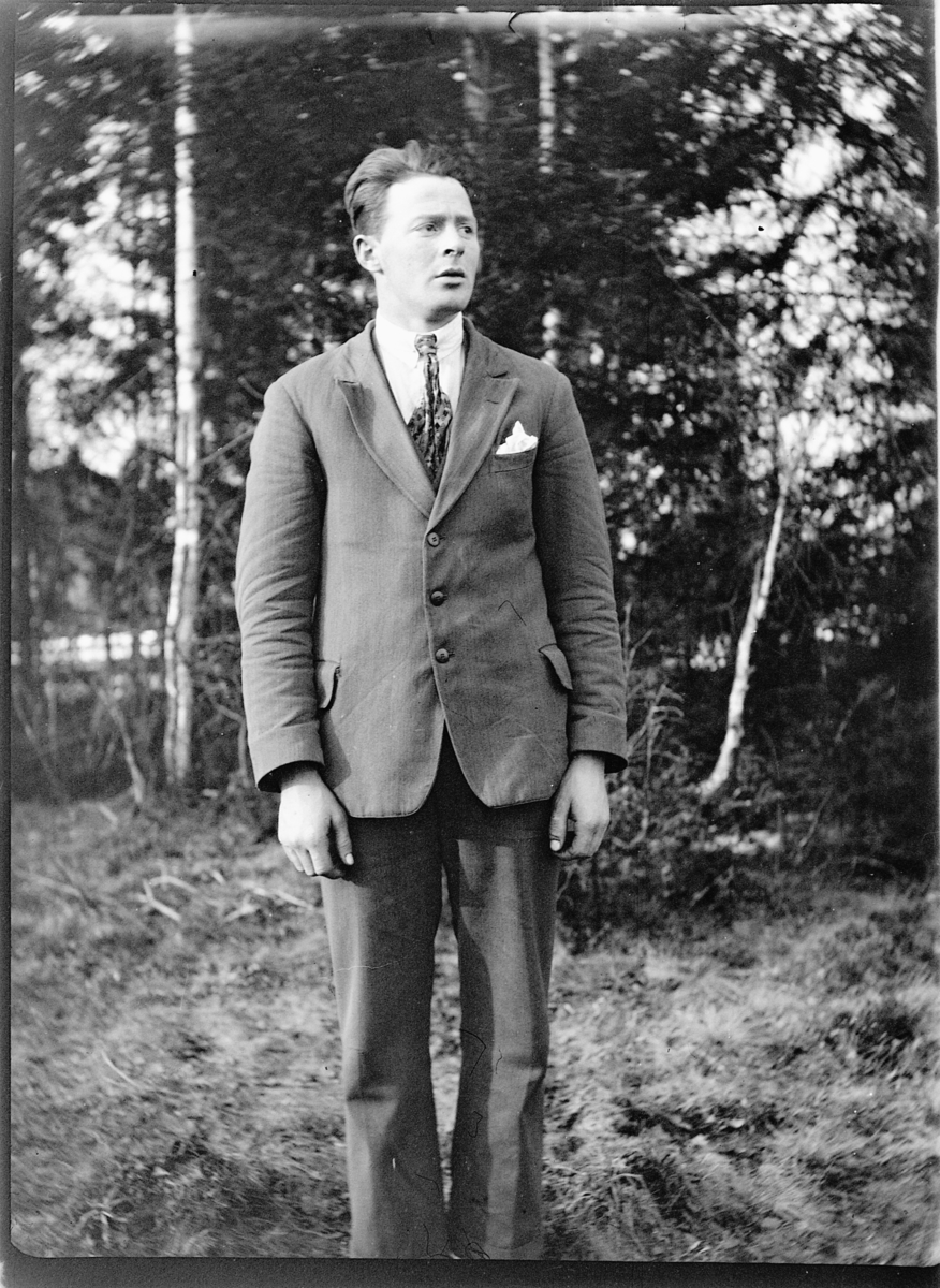 Ole M Martinsen, Eksteriør, skog. Ukjent mann i dress.