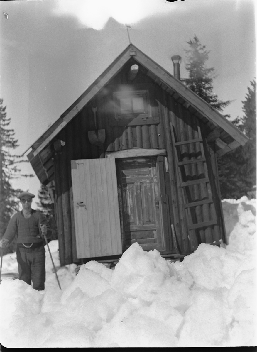 Ole M Martinsen, HYTTE, Solås. Ukjent mann med solbriller på ski. Hytta til Ole M. Martinsen (Spånestad) lå på Ruskåsen vest, Løten almenning. Det ble bygd ny hytte av familien Fuglebrenden på samme sted på 1970-tallet (Sportskapellet).