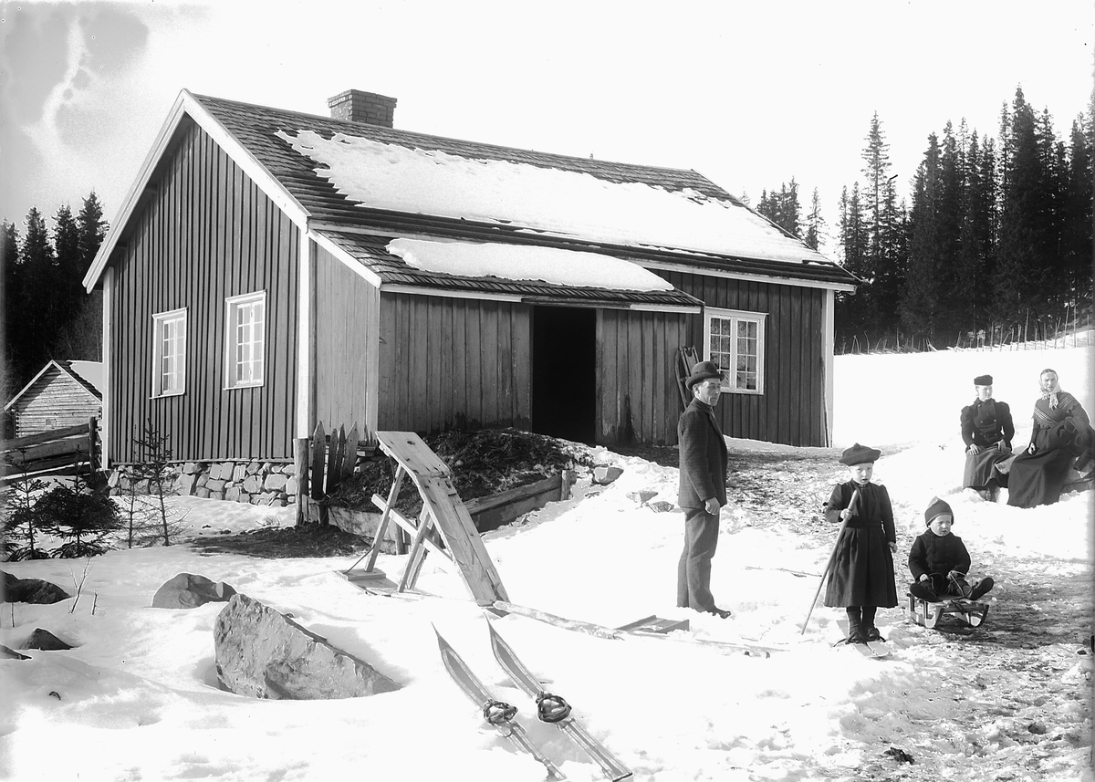 Kristoffer Horne, Ukjent familie foran et hus, ei jente på ski og en gutt på kjelke.